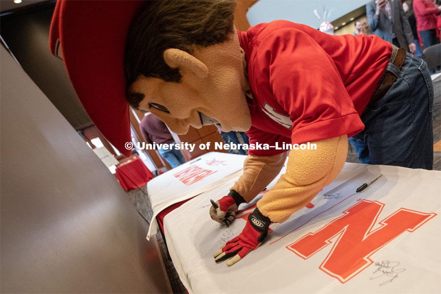 Herbie signs one of the four Alumni N150 flags. The flags will travel around the world to various alumni chapters and be signed. They will return in the fall and be hung for homecoming weekend for all to see. Everyone was invited to enjoy a cupcake and join in the festivities with their Husker friends at the Wick Alumni Center, Friday February 15th. The Nebraska Charter was available to view, along with other historical items. Copies of Dear Old Nebraska U could be purchased and signed. Charter Day at the Wick Alumni. February 15th, 2019. Photo by Gregory Nathan / University Communication.